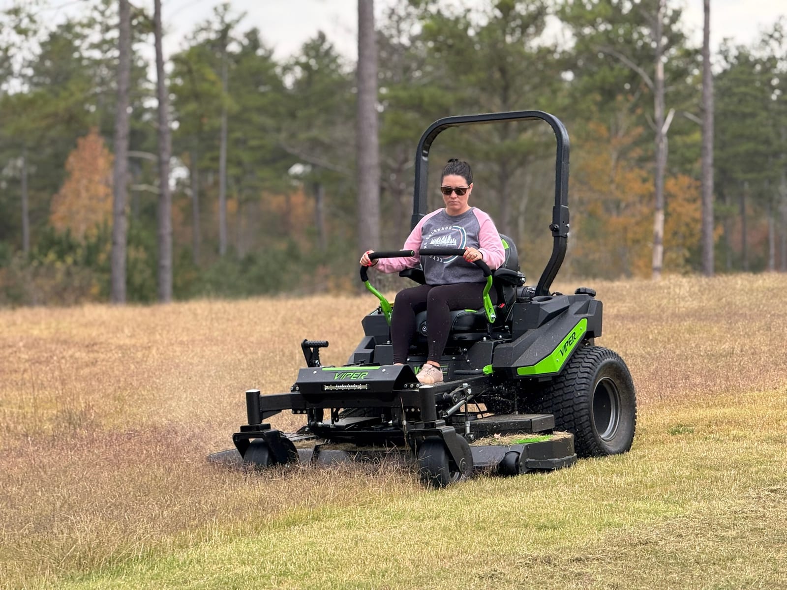 An operator mowing a lawn, side profile in an open field