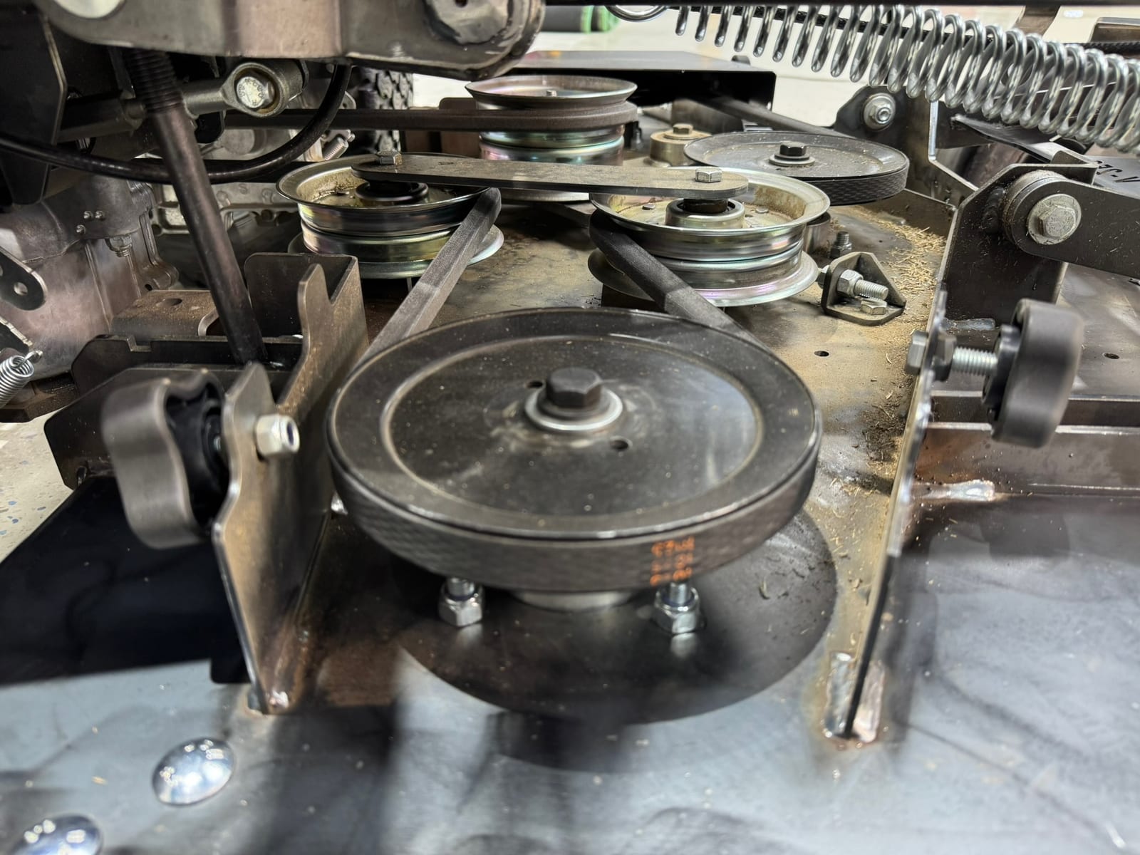 Close-up of the deck belt, pulleys and spindle drive system under a Viper mower deck
