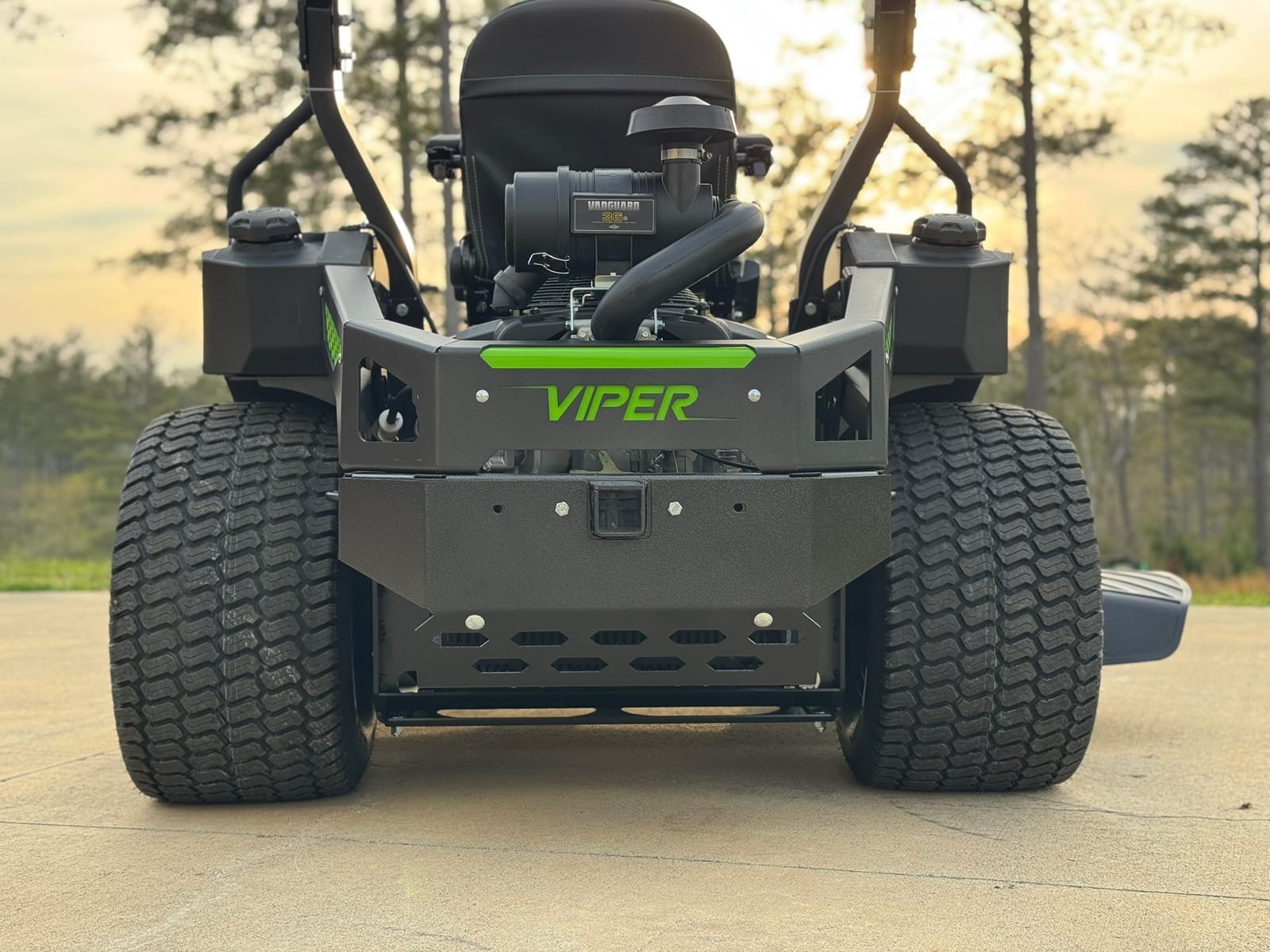 Rear of mower outdoors at sunset showing Vanguard engine, seat, big rear tires