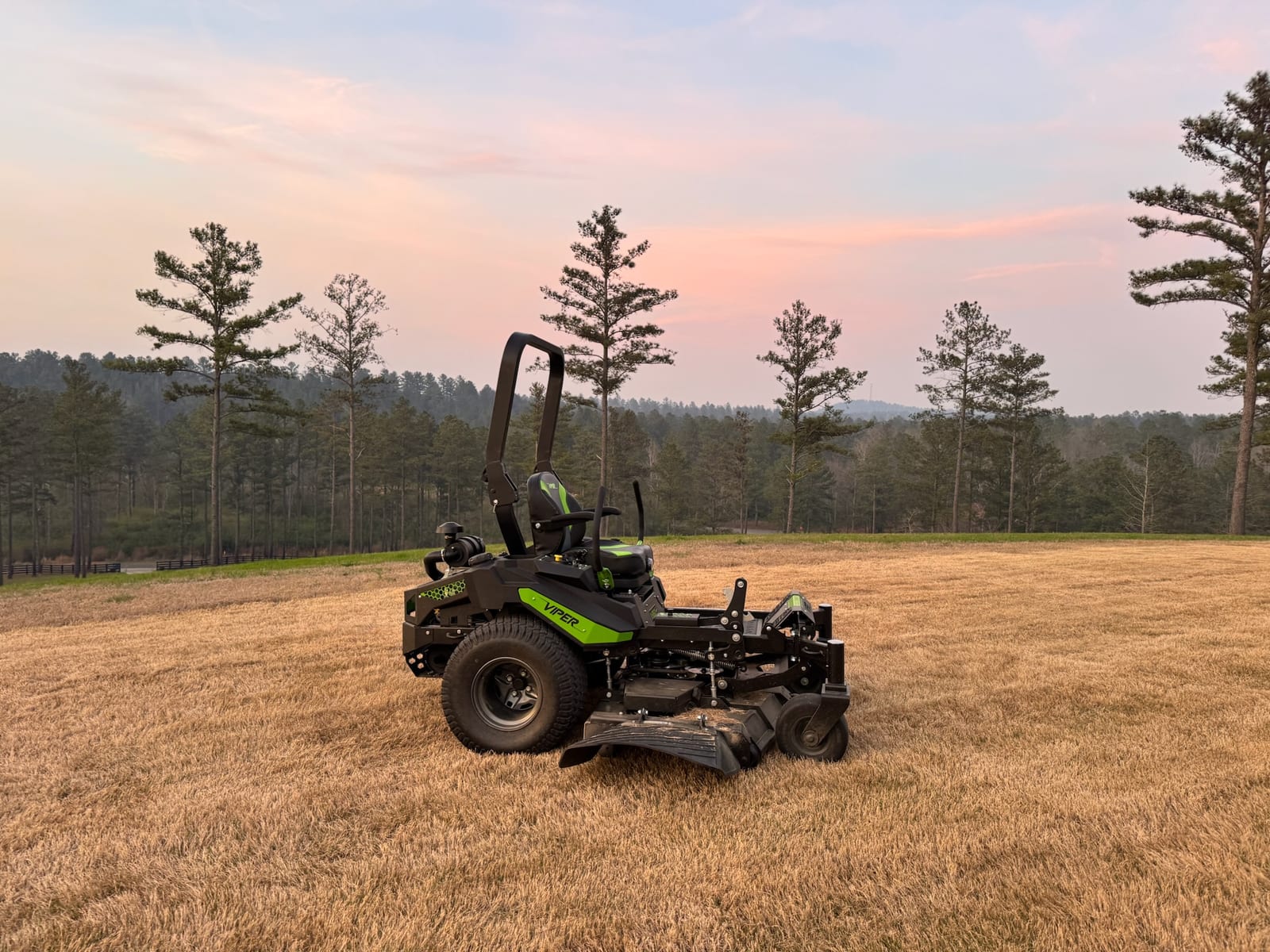 Viper zero-turn mower in profile in an open field at dusk